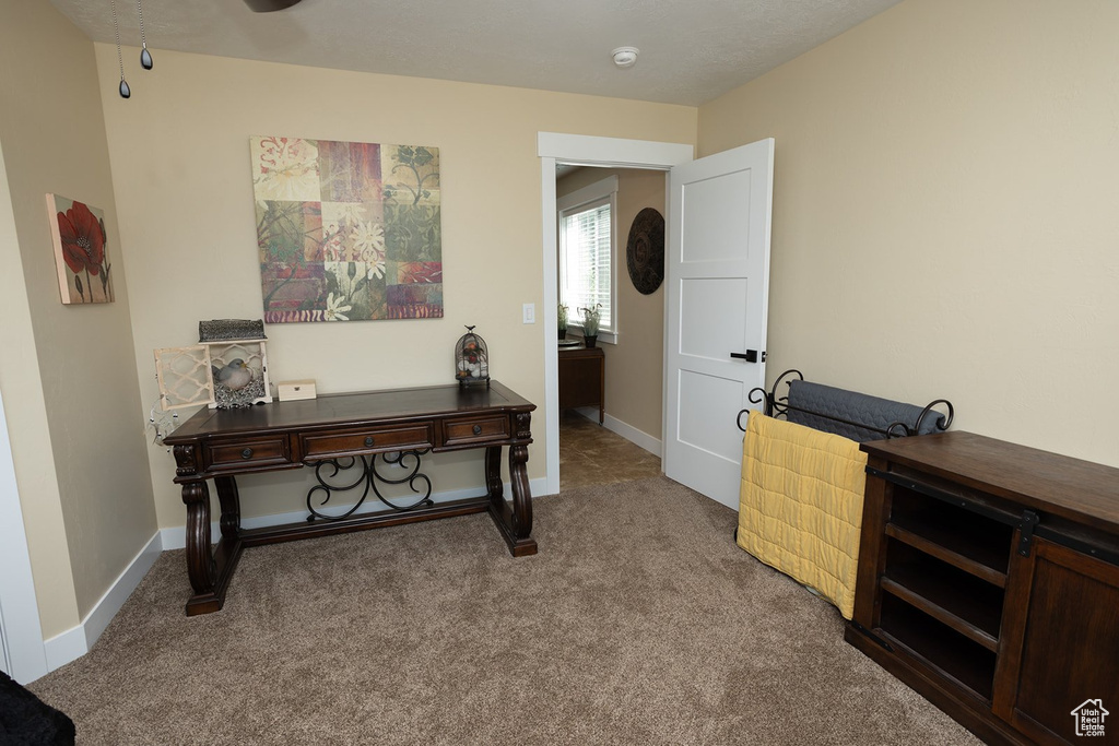Carpeted home office featuring baseboards