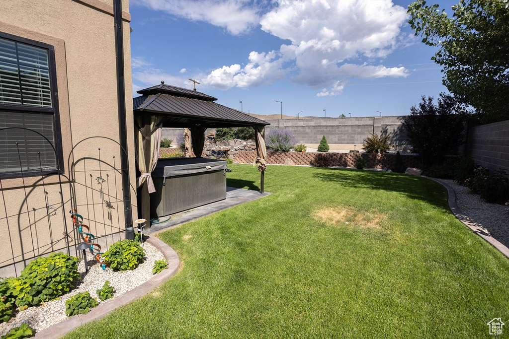Fenced backyard featuring a gazebo