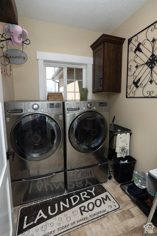 Laundry area featuring washer and clothes dryer and cabinet space