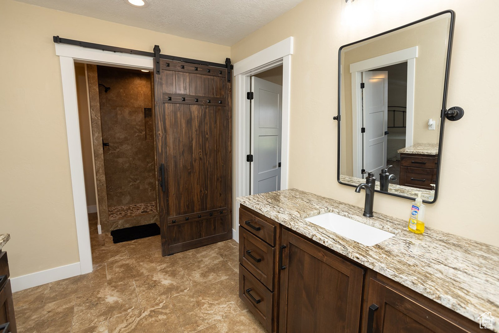 Bathroom with vanity and tiled shower
