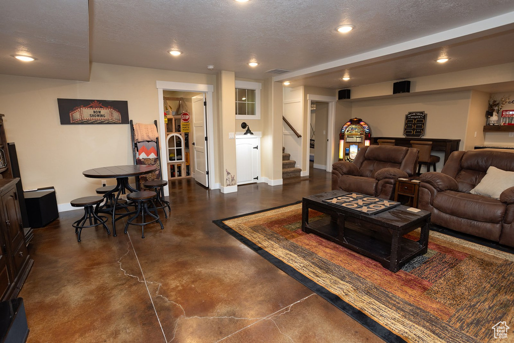 Living area featuring concrete floors, stairs, recessed lighting, and a textured ceiling