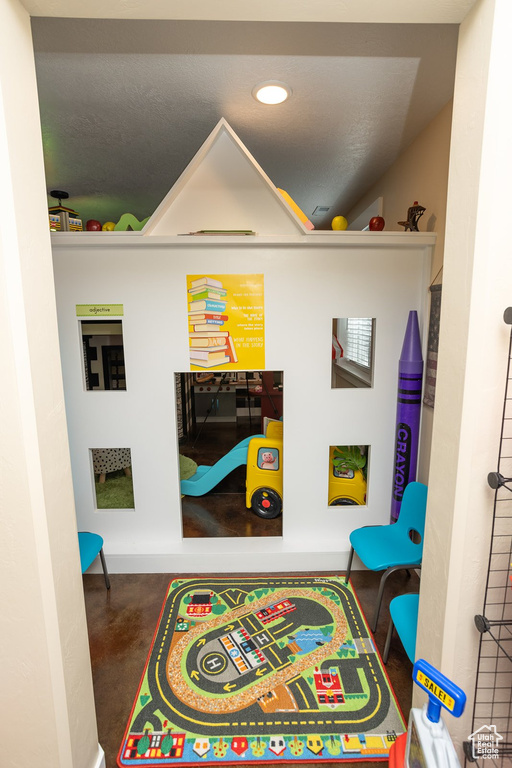 Playroom with concrete flooring and recessed lighting