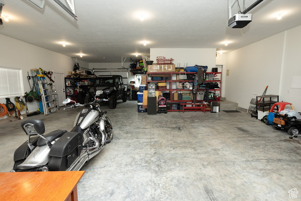 Garage featuring a garage door opener and a workshop area