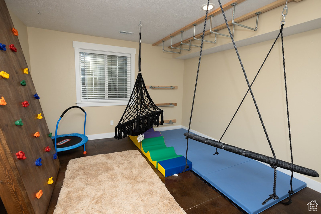 Game room with concrete floors and a textured ceiling
