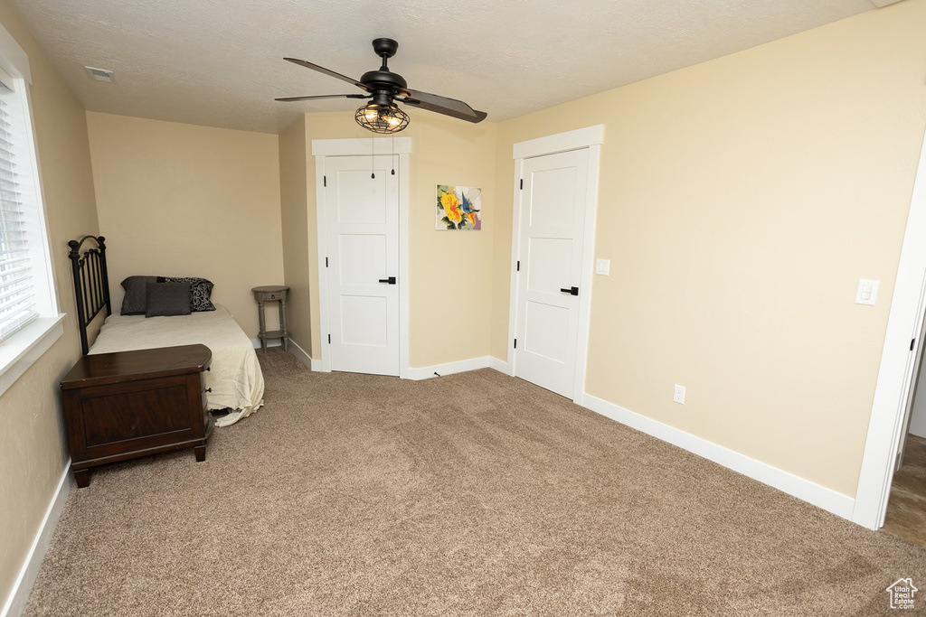 Carpeted bedroom featuring baseboards and ceiling fan