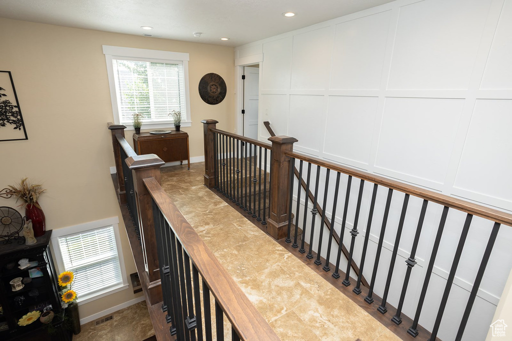 Staircase featuring recessed lighting and a decorative wall