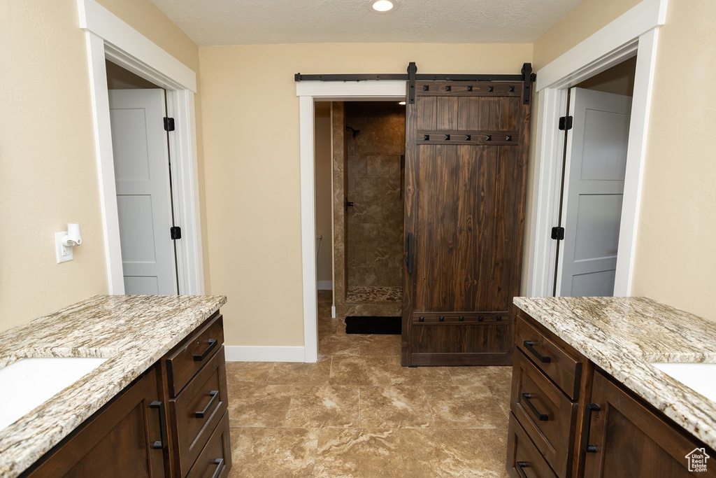 Full bath with two vanities and a tile shower