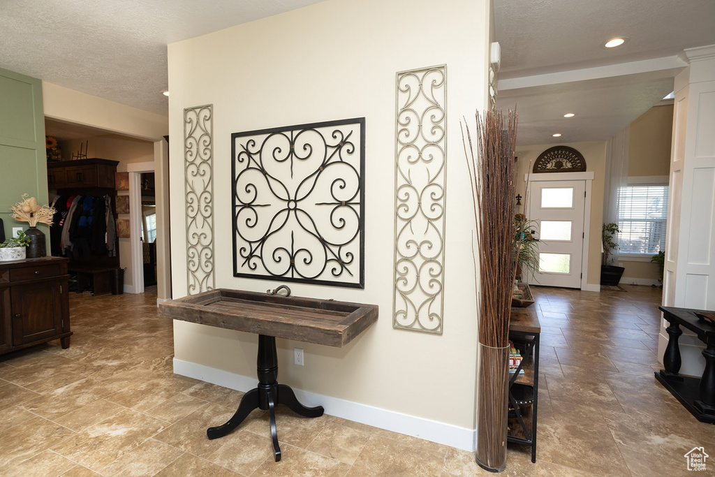 Hall featuring light stone finish floors and recessed lighting