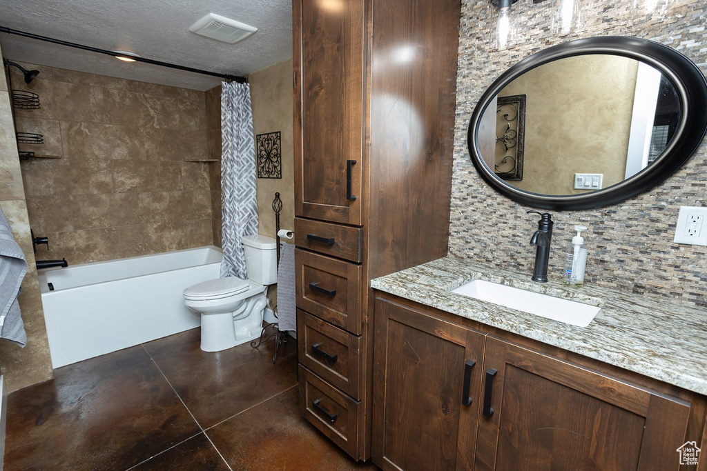 Full bath with vanity, shower / bath combo with shower curtain, tile patterned floors, backsplash, and a textured ceiling