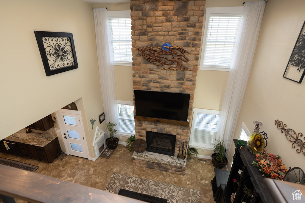 Living area featuring a stone fireplace and baseboards