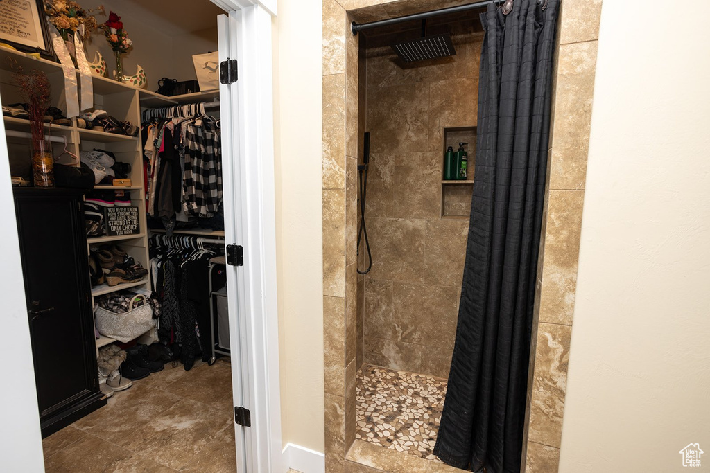 Bathroom with a tile shower and a spacious closet