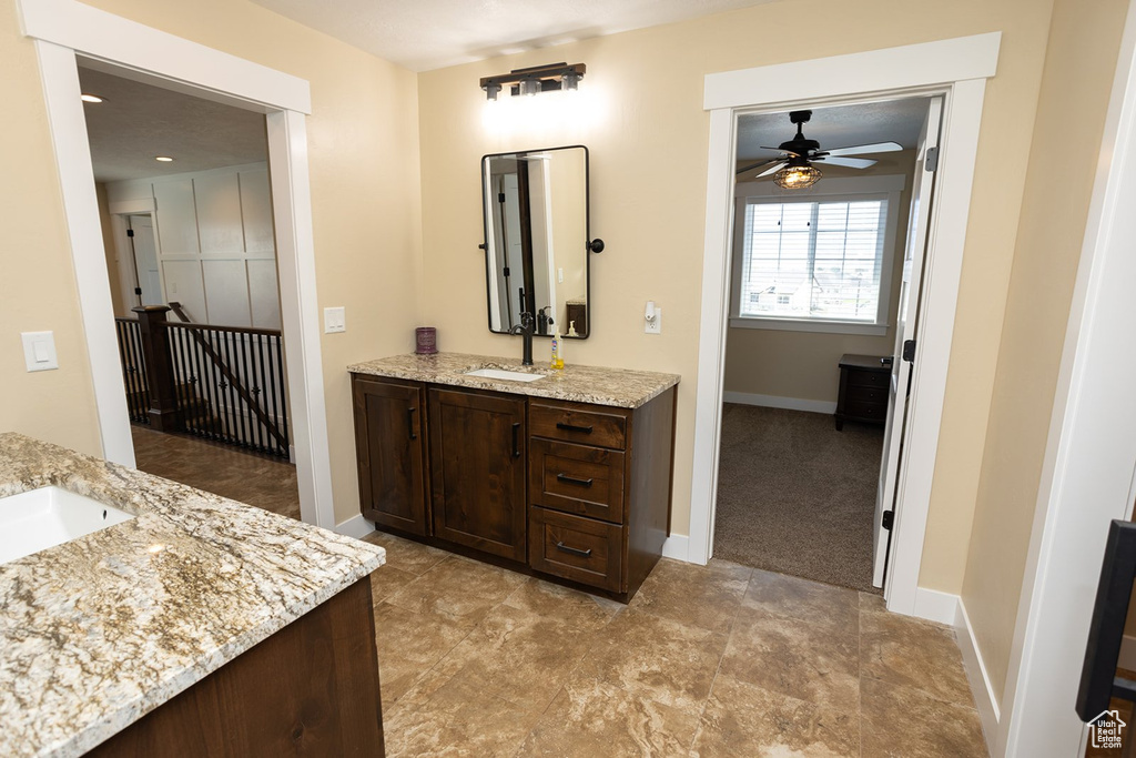 Full bathroom with two vanities and a ceiling fan