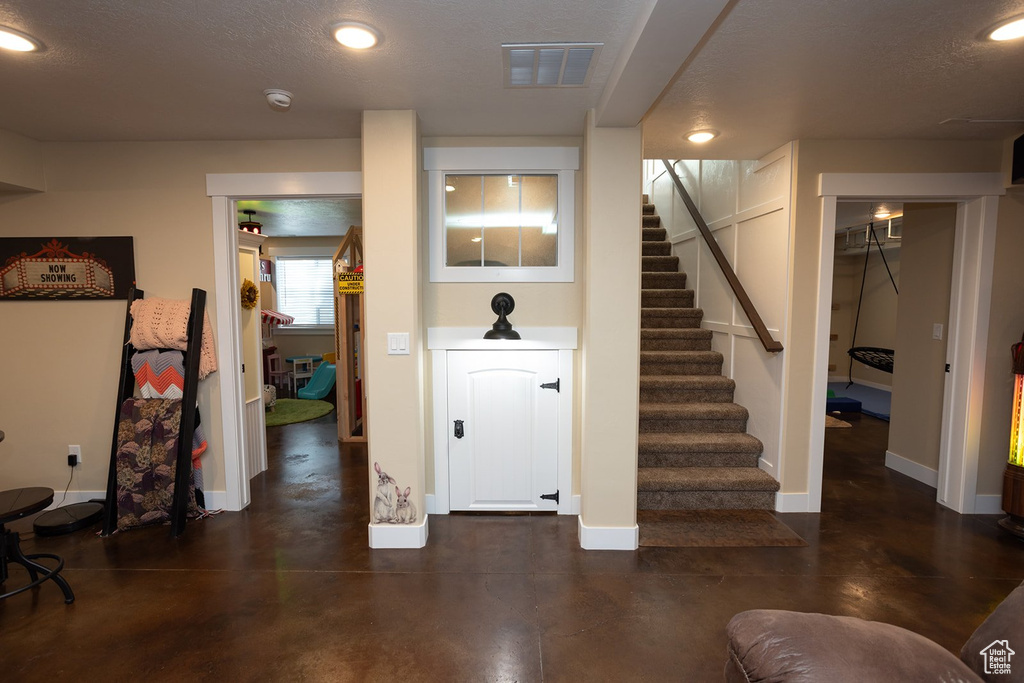 Below grade area featuring stairs and recessed lighting