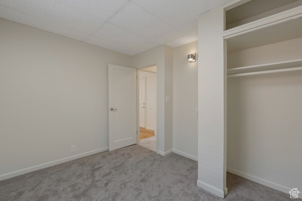 Unfurnished bedroom featuring carpet and a drop ceiling