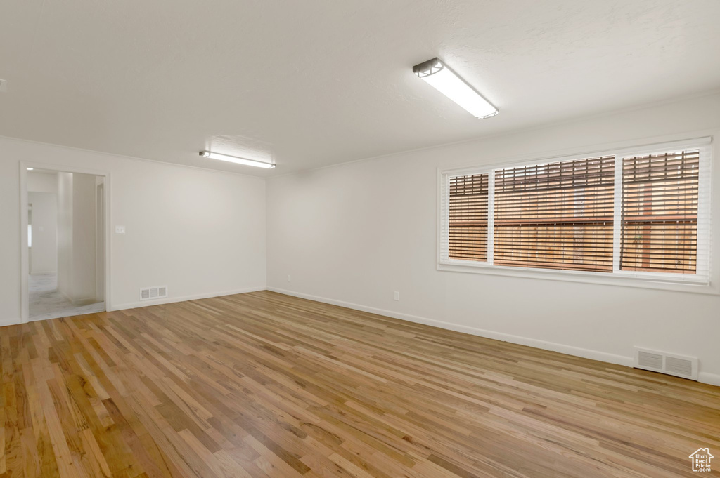 Spare room featuring light wood-style floors and baseboards