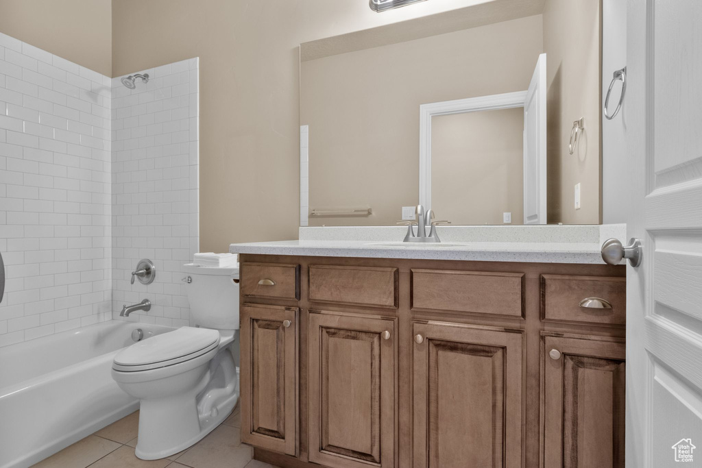 Bathroom featuring vanity, tub / shower combination, and tile patterned flooring