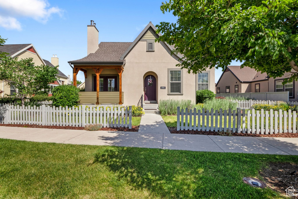 View of front of property featuring stucco siding, a chimney, and a fenced front yard