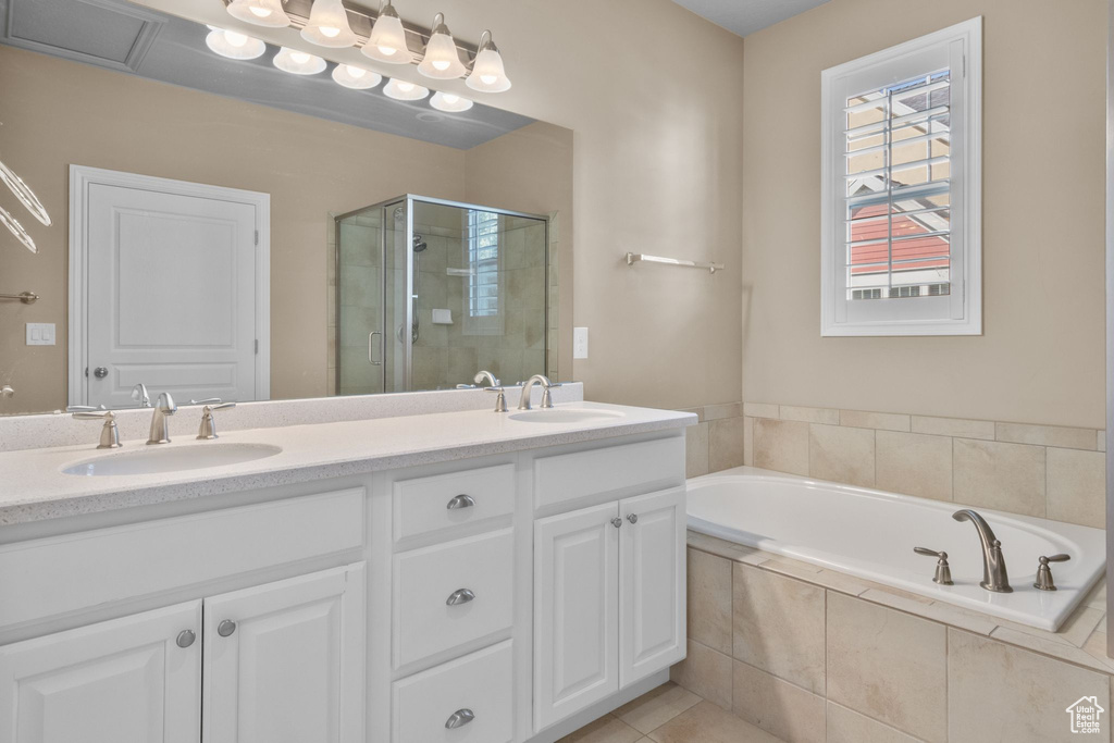 Bathroom featuring a stall shower, double vanity, a bath, and tile patterned floors