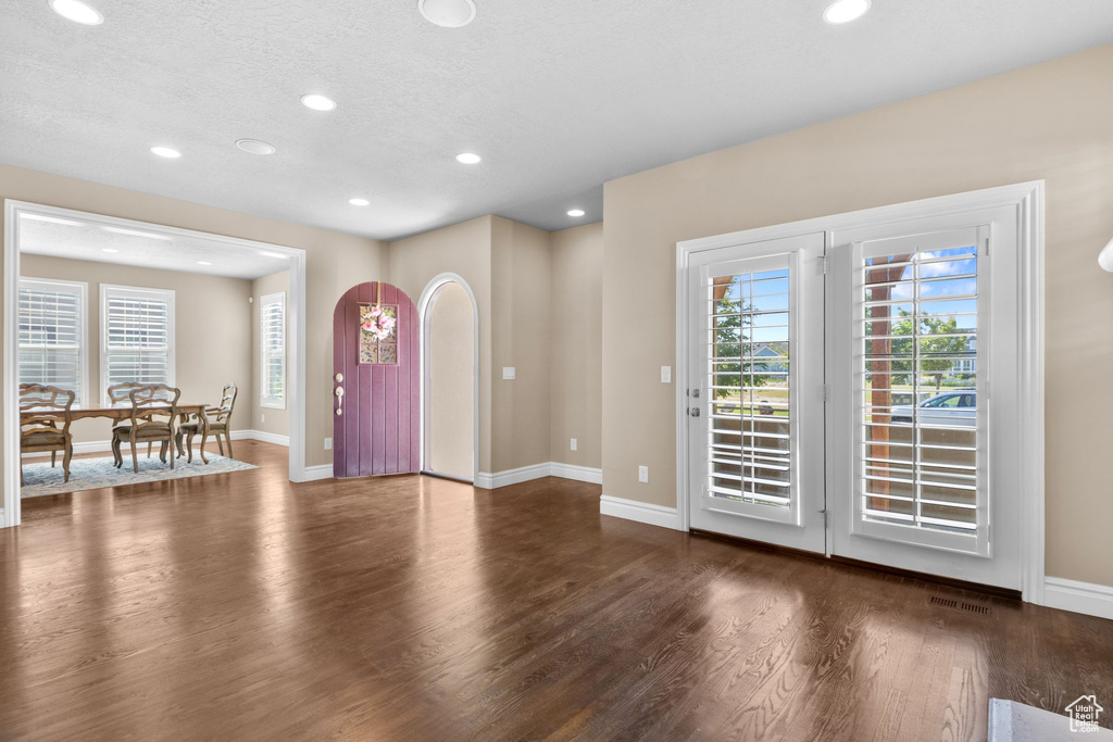 Foyer entrance with wood finished floors, recessed lighting, healthy amount of natural light, and a textured ceiling