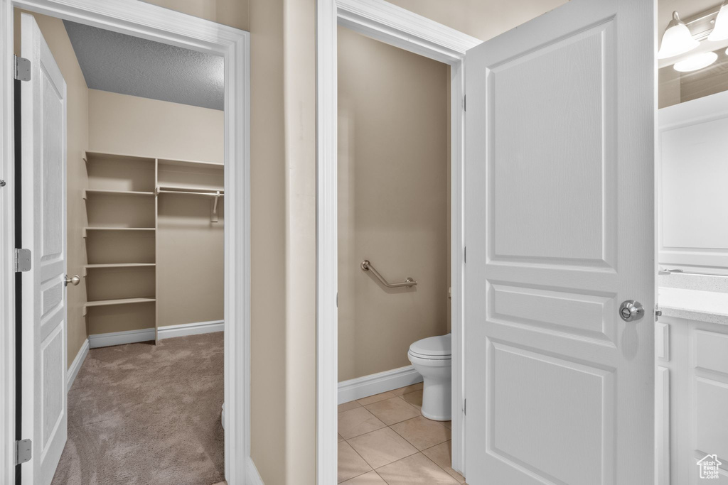 Bathroom with a spacious closet and tile patterned floors