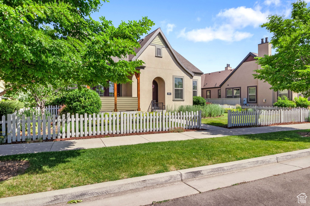 View of front of home featuring stucco siding and a front lawn