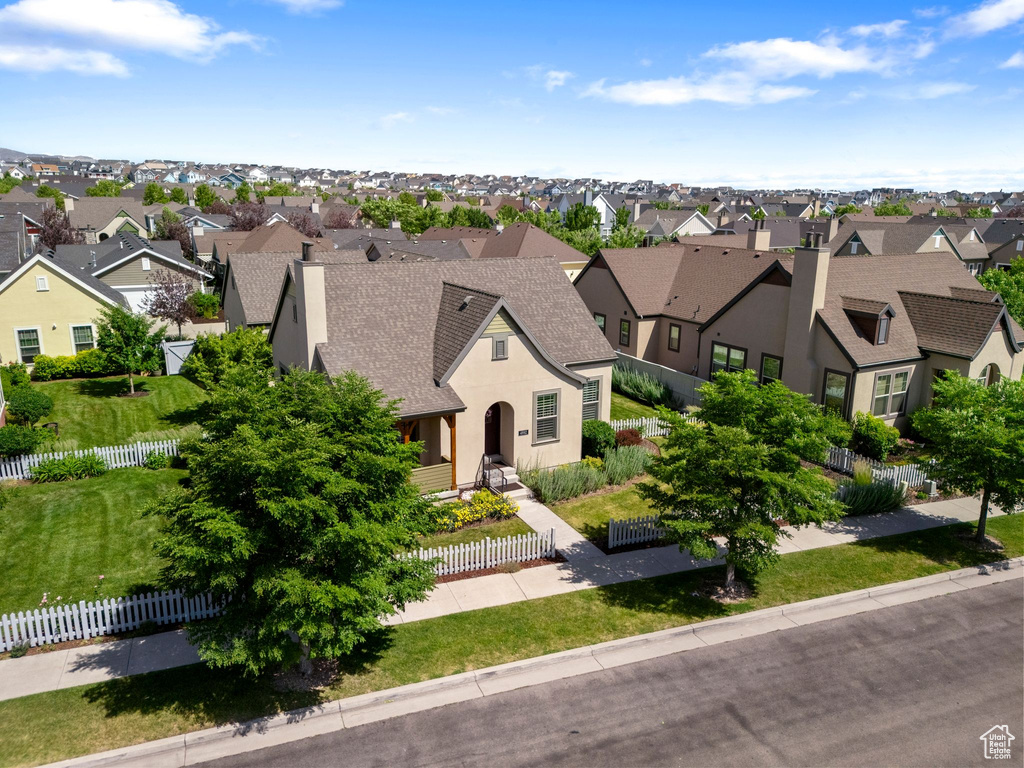 View of front of property with a residential view, a shingled roof, a fenced front yard, and stucco siding