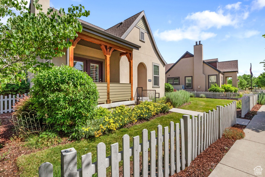View of front of house featuring stucco siding, a chimney, and a porch