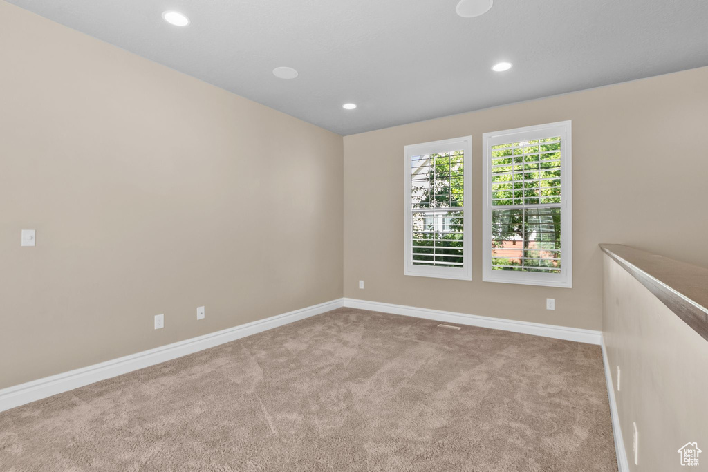 Carpeted empty room with baseboards and recessed lighting