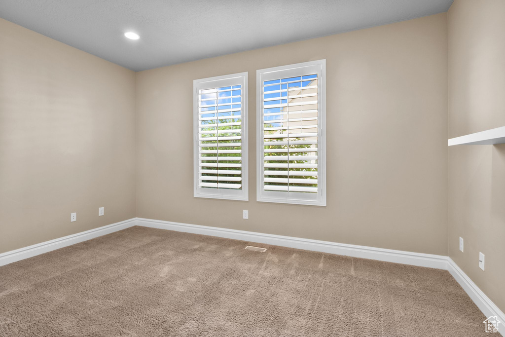 Empty room with carpet flooring and recessed lighting