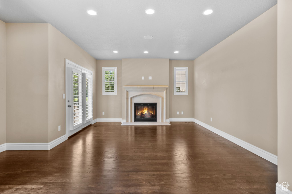 Unfurnished living room featuring wood finished floors, recessed lighting, and a high end fireplace
