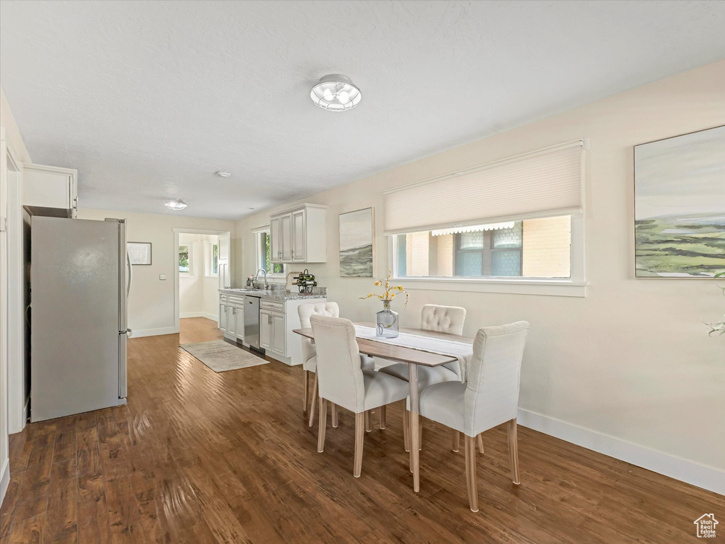 Dining room featuring baseboards and dark wood-style flooring