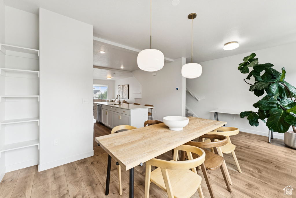 Dining area with light wood-style floors and stairs