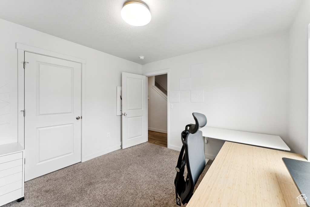 Carpeted home office featuring baseboards