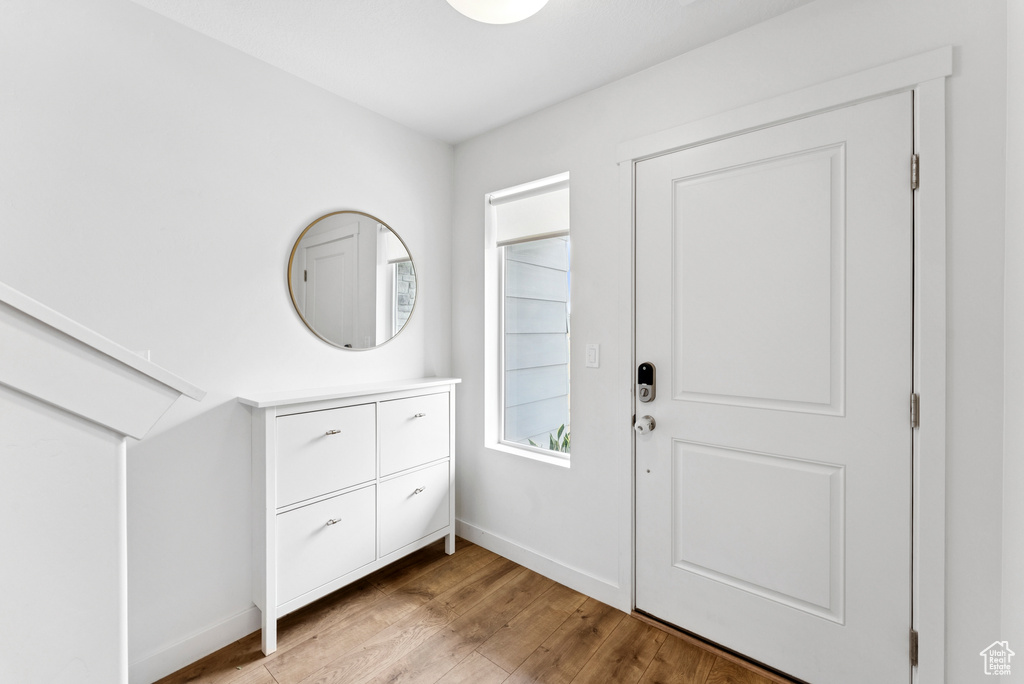 Foyer entrance with light wood-type flooring and baseboards