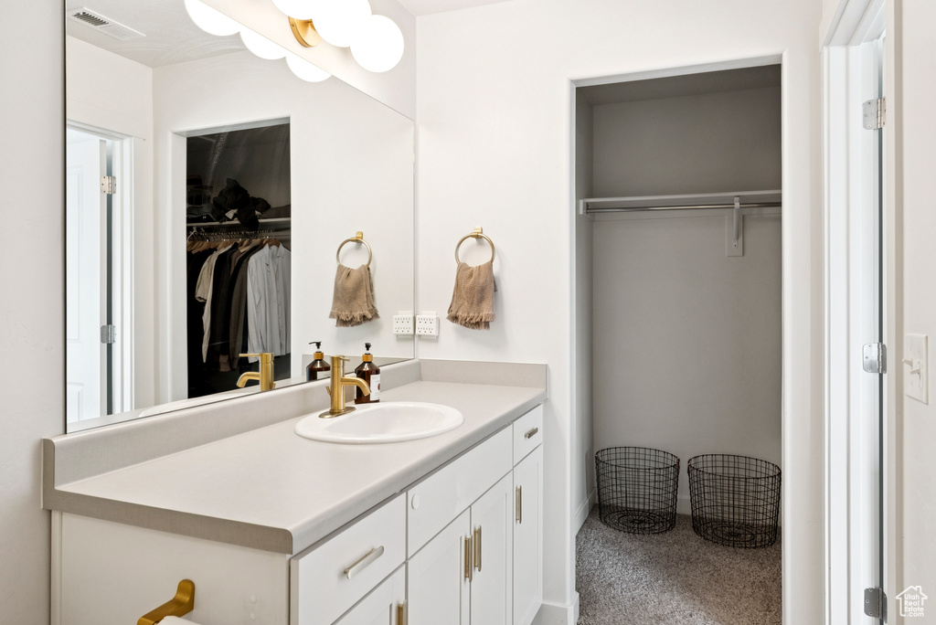 Bathroom featuring vanity and a spacious closet