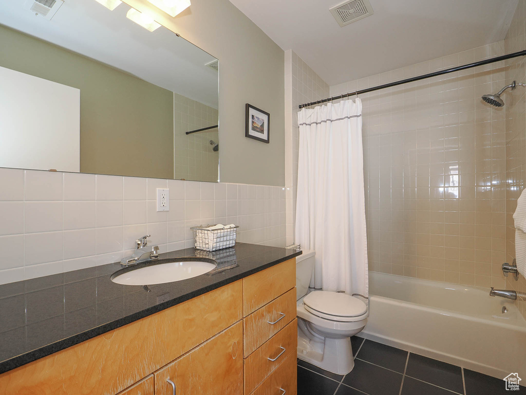 Bathroom featuring tile patterned floors, shower / bath combo with shower curtain, toilet, vanity, and backsplash