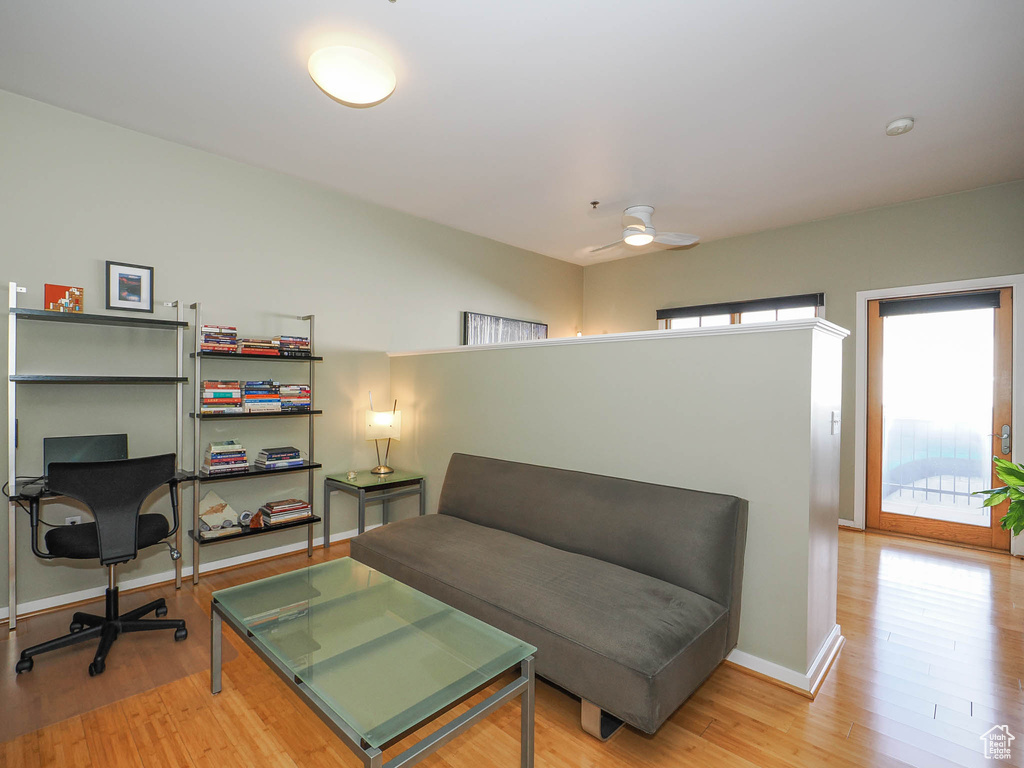 Living area with light wood finished floors, baseboards, and ceiling fan