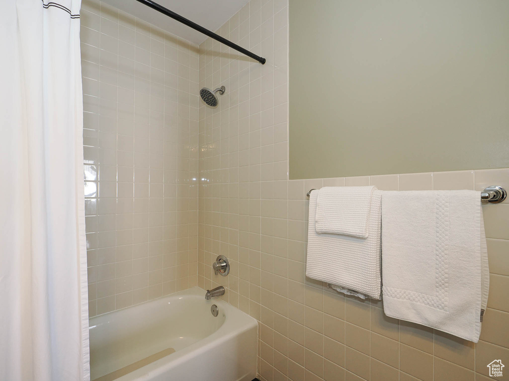 Full bathroom with tile walls and bathtub / shower combination