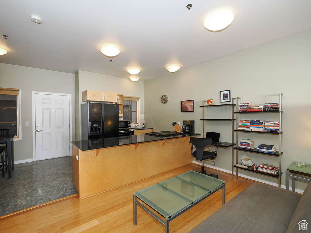 Living area featuring an office area, light wood-style flooring, and baseboards