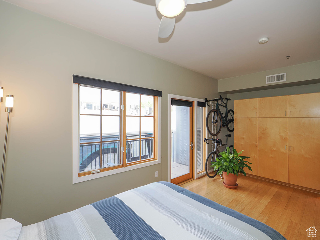 Bedroom with access to outside, wood finished floors, and a ceiling fan