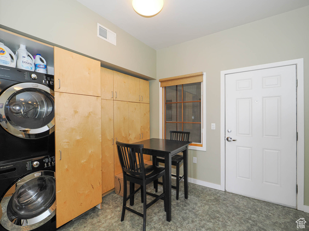 Dining space featuring stacked washer and clothes dryer and baseboards