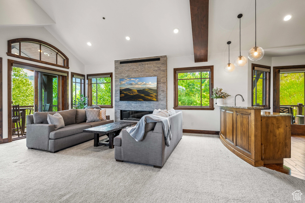 Living room featuring light colored carpet, recessed lighting, beam ceiling, and a fireplace
