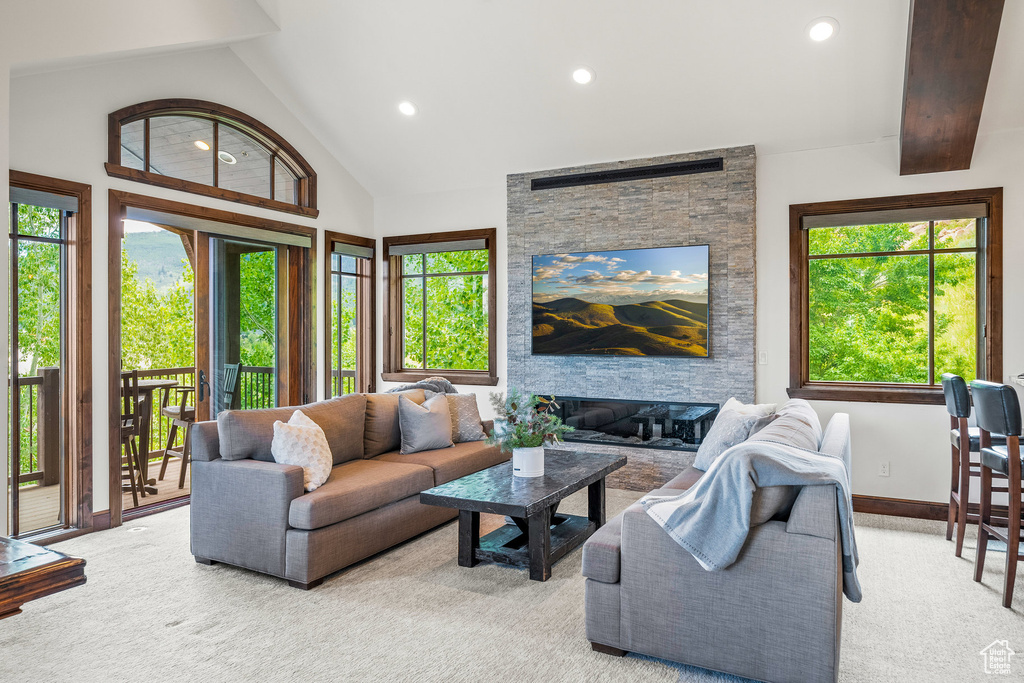 Carpeted living area featuring recessed lighting, vaulted ceiling, and a fireplace