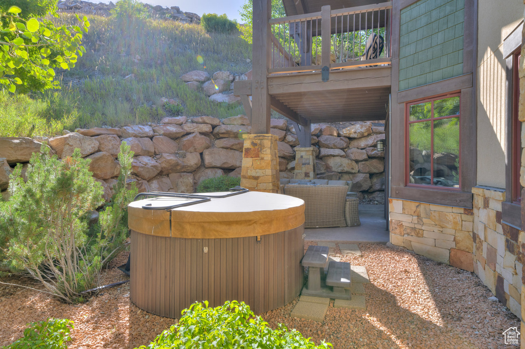 View of patio / terrace featuring a hot tub and a deck
