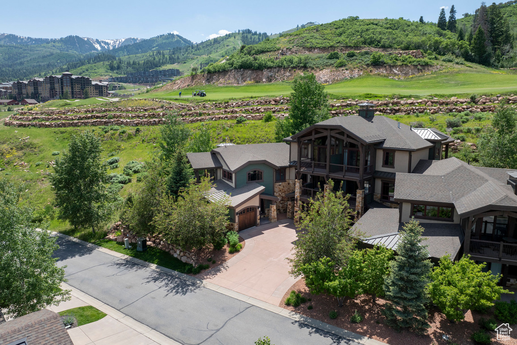 Aerial view of property and surrounding area with a mountain backdrop