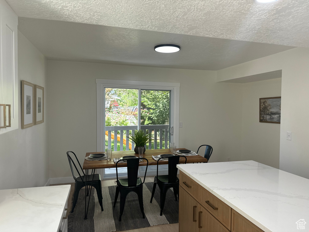 Dining space with a textured ceiling and light wood-style flooring