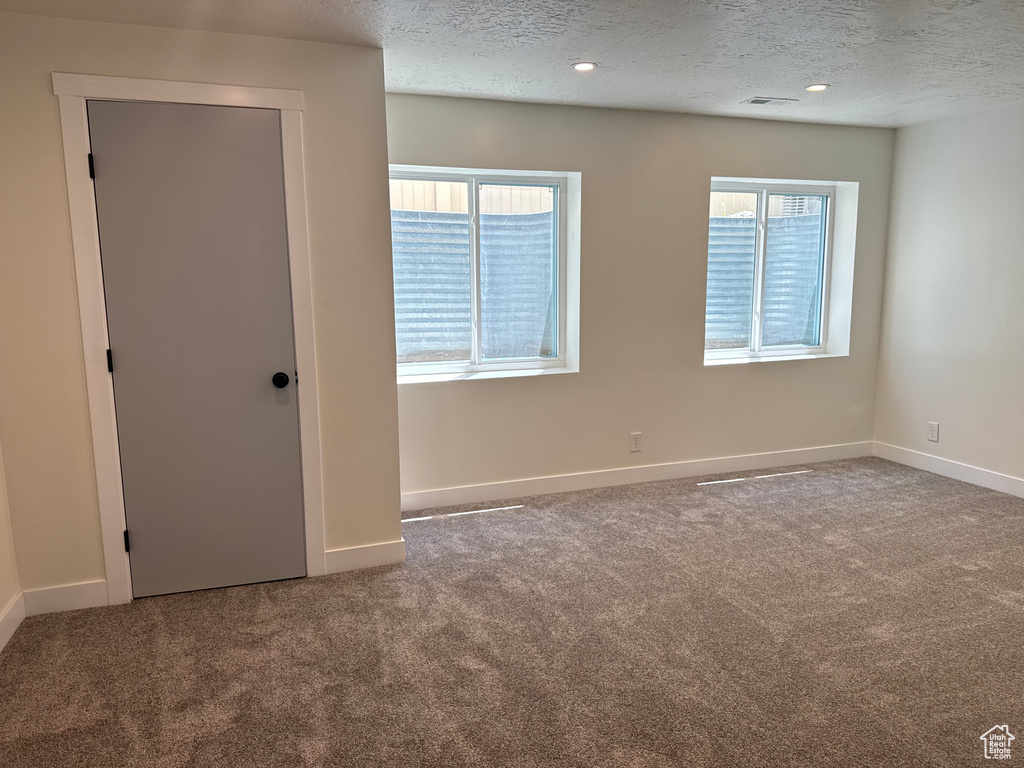 Unfurnished room with carpet, a textured ceiling, and recessed lighting