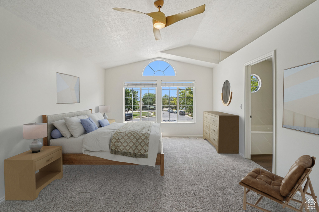 Carpeted bedroom with vaulted ceiling, ceiling fan, and a textured ceiling