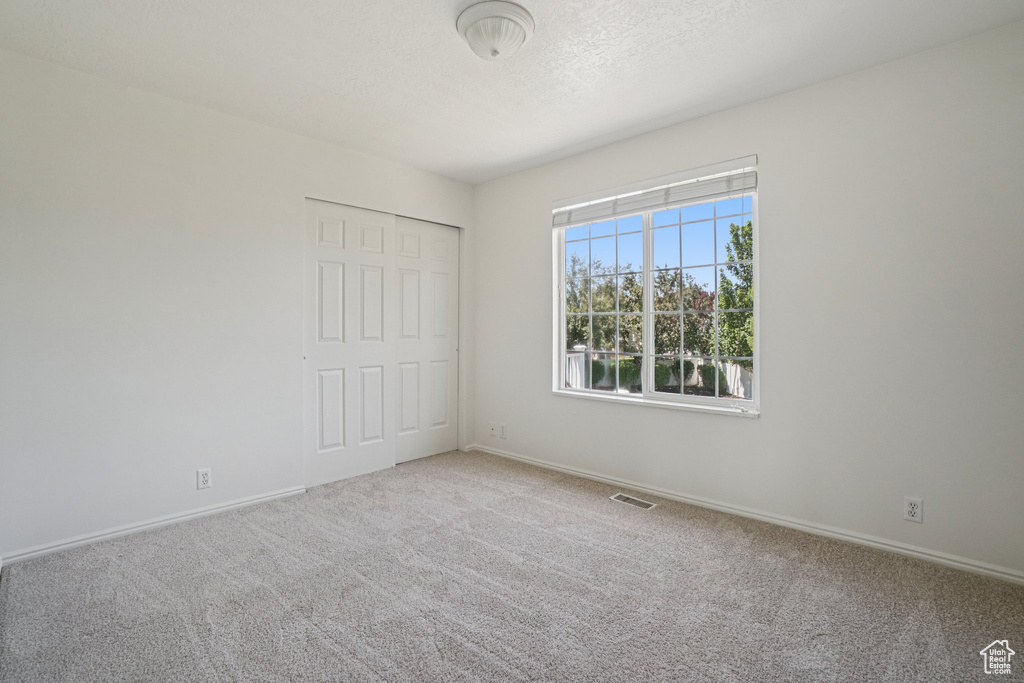 Unfurnished bedroom featuring carpet flooring and a closet