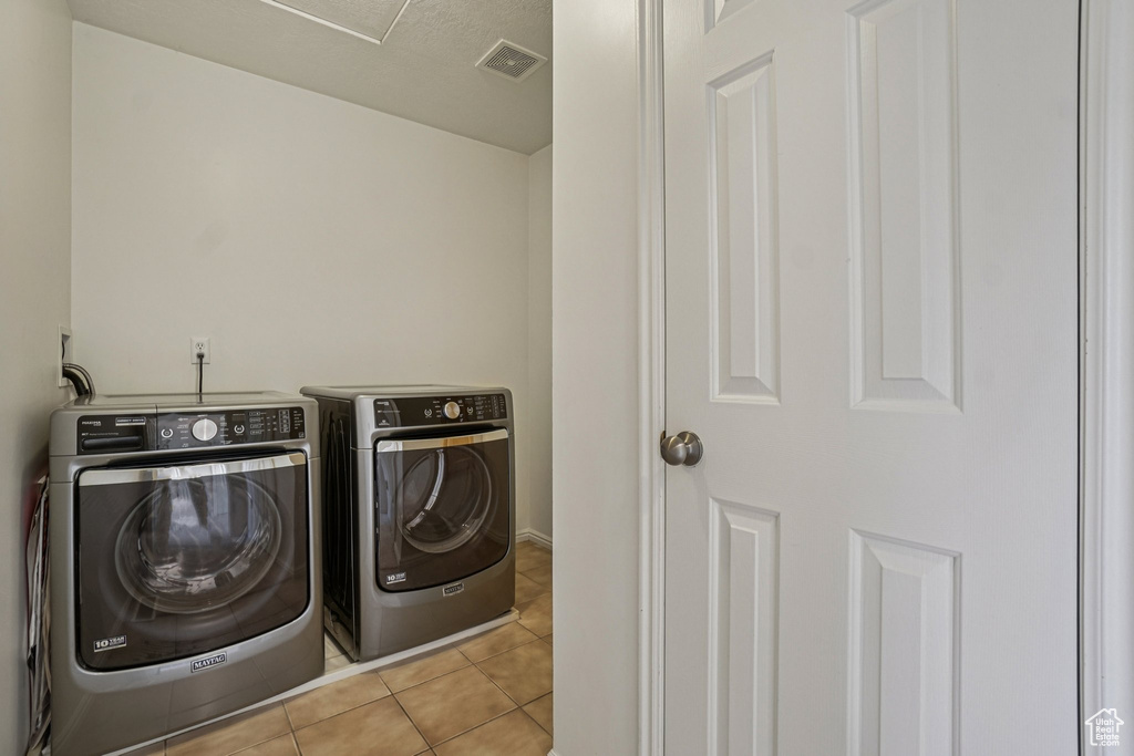 Washroom featuring independent washer and dryer and tile patterned floors